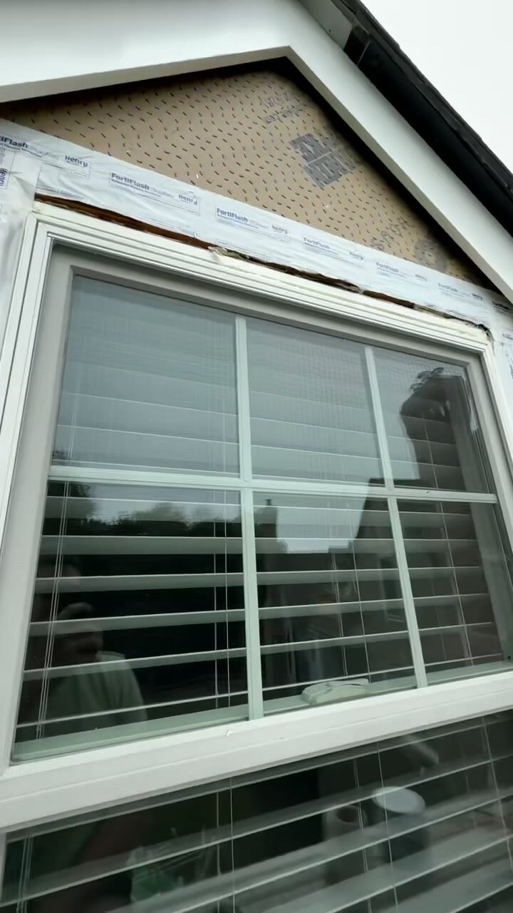 Newly installed bow window with fresh white trim and weather flashing.
